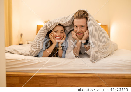 Cute couple having fun under the blanket in the bedroom Cute couple having fun under the blanket in the bedroom 141423793