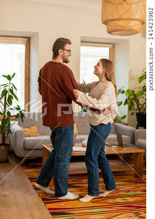 Young couple dancing in an old-fashioned room and feeling contented and happy Young couple dancing in an old-fashioned room and feeling contented and happy 141423962