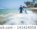 Caucasian father and son playing in ocean waves on tropical Sri Lankan beach 141424058