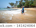 Caucasian father and son playing joyfully on a tropical beach in Sri Lanka 141424064