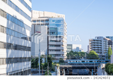 [Keihin-Tohoku Line] A local train passing through the streets of Kawasaki in the early morning. 141424072