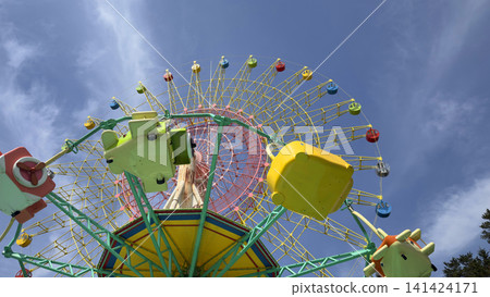 An amusement park with a Ferris wheel floating in the blue sky. An amusement park with a Ferris wheel floating in the blue sky. 141424171