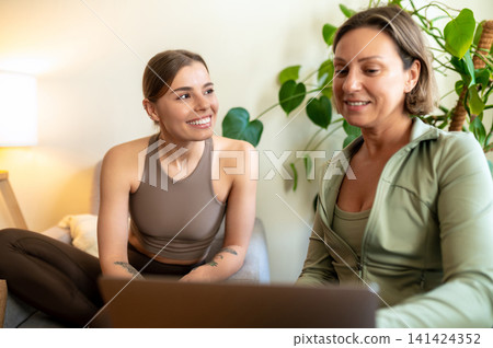 Fitness coach and student looking at screen Fitness coach and student looking at screen 141424352