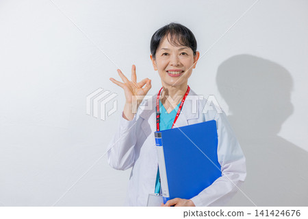 一位經驗豐富的醫生微笑著拿著一份文件。 一位經驗豐富的醫生微笑著拿著一份文件。 141424676