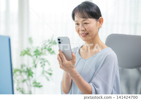 操作智能手機的資深婦女 141424700