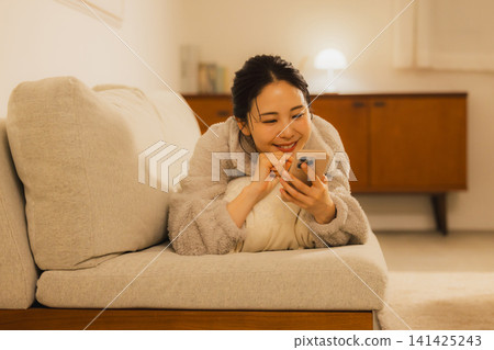 A woman watching a night smartphone 141425243