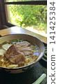 窗邊桌上擺著一份沖繩蕎麥麵配五花肉。 141425384