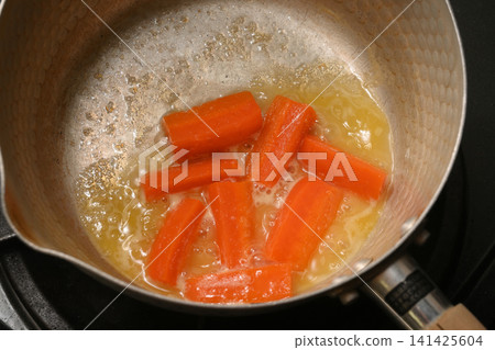 Carrot glacé being cooked Carrot glacé being cooked 141425604