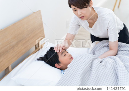 A mother caring for her feverish child. A mother caring for her feverish child. 141425791