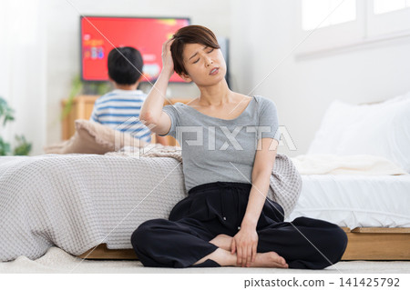 A mother is stressed because her elementary school-aged child won't stop playing video games during summer vacation. A mother is stressed because her elementary school-aged child won't stop playing video games during summer vacation. 141425792