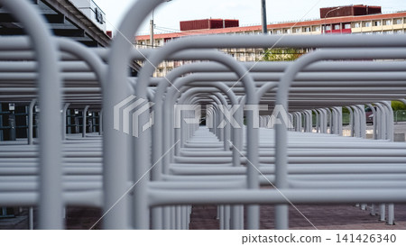 View through rows of metal railings at stadium entrance forming tunnel-like perspective. Repetitive structure with strong depth and minimal composition. View through rows of metal railings at stadium entrance forming tunnel-like perspective. Repetitive structure with strong depth and minimal composition. 141426340