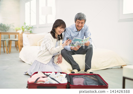 A smiling senior couple preparing for a trip. A smiling senior couple preparing for a trip. 141426388