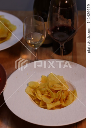Chips and Wine Glasses on Wooden Table 141426659