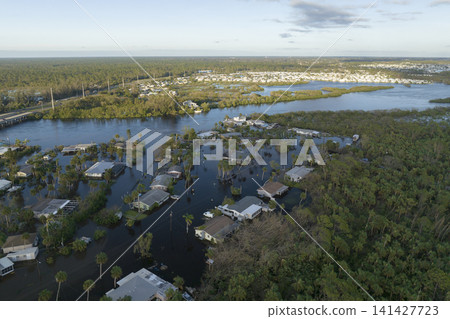 Consequences of natural disaster. Heavy flood with high water surrounding residential houses after hurricane rainfall in Florida residential area Consequences of natural disaster. Heavy flood with high water surrounding residential houses after hurricane rainfall in Florida residential area 141427723