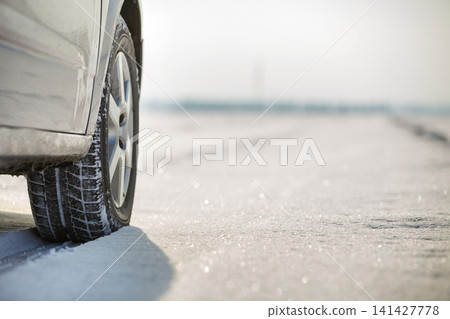 Close-up of car wheels rubber tire in deep snow. Transportation and safety concept. Close-up of car wheels rubber tire in deep snow. Transportation and safety concept. 141427778