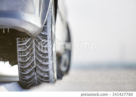 Close-up of car wheels rubber tire in deep snow. Transportation and safety concept. Close-up of car wheels rubber tire in deep snow. Transportation and safety concept. 141427780