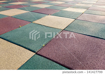 Close up of soft rubber tiles for covering at outdoor gym of stadium at preschool yard. Close up of soft rubber tiles for covering at outdoor gym of stadium at preschool yard. 141427799