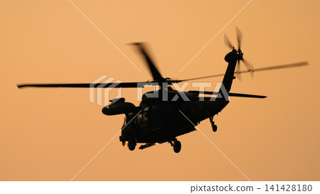 A Japan Air Self-Defense Force UH-60JII rescue helicopter flying at dusk. A Japan Air Self-Defense Force UH-60JII rescue helicopter flying at dusk. 141428180