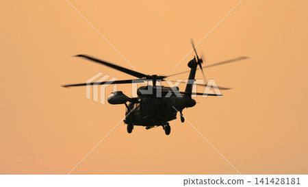 A Japan Air Self-Defense Force UH-60JII rescue helicopter flying at dusk. A Japan Air Self-Defense Force UH-60JII rescue helicopter flying at dusk. 141428181