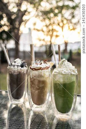 Chocolate and Coffee ice cream sundae milkshake drinks on outdoor cafe table 141430303