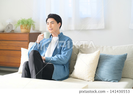 一位日本男子正在放鬆地喝咖啡。 一位日本男子正在放鬆地喝咖啡。 141430553