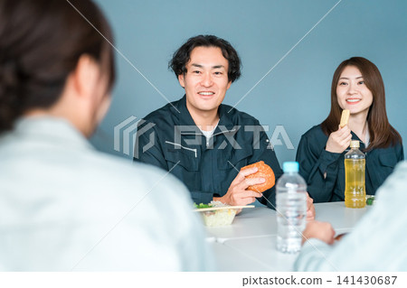 穿著工作服的商人和女士們在休息室吃午餐 141430687