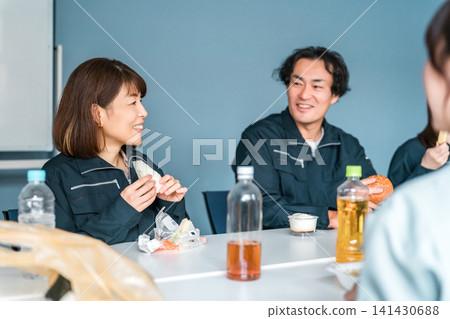 穿著工作服的商人和女士們在休息室吃午餐 141430688