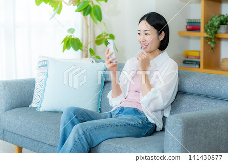 A woman who operates a smartphone in the room A woman who operates a smartphone in the room 141430877