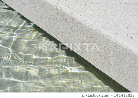 Concrete fountain edge with clear rippling water Concrete fountain edge with clear rippling water 141432022