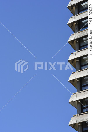 Brutalist concrete apartment building balconies against blue sky Brutalist concrete apartment building balconies against blue sky 141432039