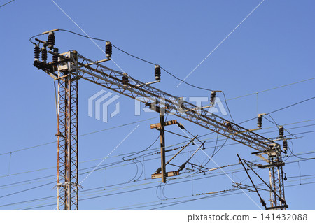 Railway catenary steel gantry with electrical components against a blue sky Railway catenary steel gantry with electrical components against a blue sky 141432088