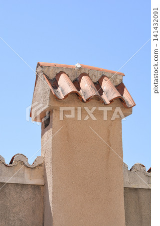 Traditional Mediterranean chimney on a wall against blue sky Traditional Mediterranean chimney on a wall against blue sky 141432091