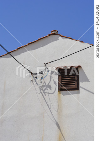 Old house facade with window shutters and tangled cables 141432092