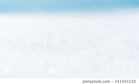 The sparkling shine of snow against a blue background The sparkling shine of snow against a blue background 141432220