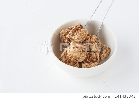 Brown sugar on a white plate Brown sugar on a white plate 141432342