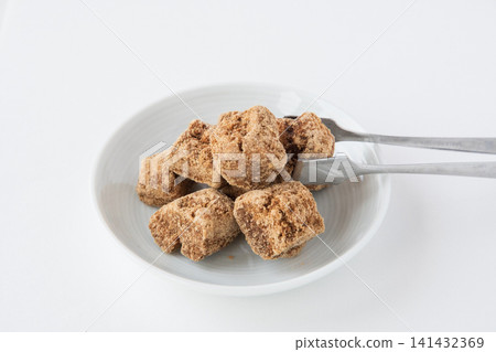 Close-up of brown sugar on a white plate Close-up of brown sugar on a white plate 141432369