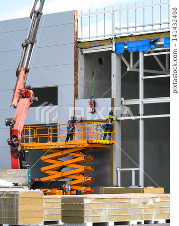 Installing Insulated Sandwich Wall Panels with Scissor Lift at Modern Industrial Construction Site Installing Insulated Sandwich Wall Panels with Scissor Lift at Modern Industrial Construction Site 141432498