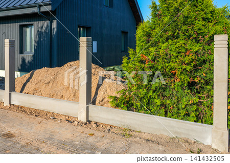 Modern precast concrete fence installation around residential property during landscape construction project Modern precast concrete fence installation around residential property during landscape construction project 141432505