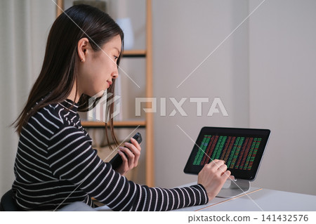 A woman checking stock prices A woman checking stock prices 141432576