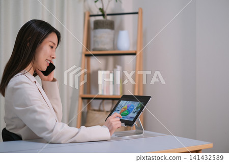 A woman is discussing investments while looking at a tablet. A woman is discussing investments while looking at a tablet. 141432589