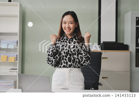 Confident asian business woman standing in modern office Confident asian business woman standing in modern office 141433113