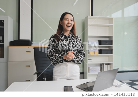 Confident asian business woman standing in modern office Confident asian business woman standing in modern office 141433118