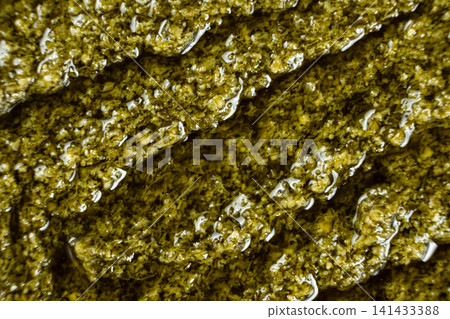 Traditional Italian basil pesto background top view Traditional Italian basil pesto background top view 141433388