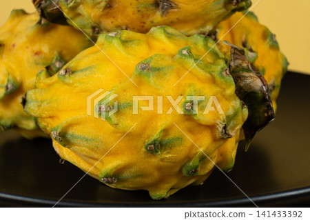 Group of whole raw exotic yellow pitahaya dragonfruits Group of whole raw exotic yellow pitahaya dragonfruits 141433392