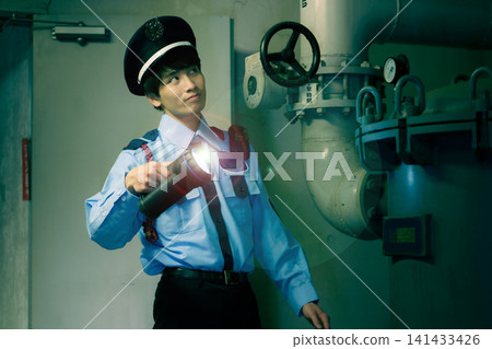 一名手持手電筒的男性保全正在建築物地下室巡邏。照片由東京電子學院電波學園教育基金會提供。 一名手持手電筒的男性保全正在建築物地下室巡邏。照片由東京電子學院電波學園教育基金會提供。 141433426