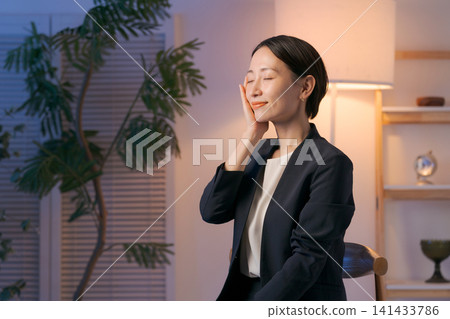 一位身穿西裝的女士正在塗抹護膚品。 一位身穿西裝的女士正在塗抹護膚品。 141433786