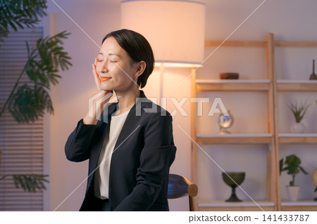 A woman in a suit applying skincare products. A woman in a suit applying skincare products. 141433787