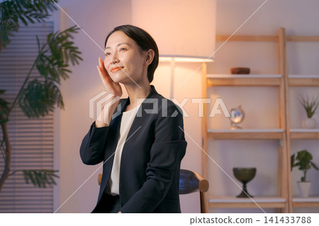 一位身穿西裝的女士正在塗抹護膚品。 一位身穿西裝的女士正在塗抹護膚品。 141433788