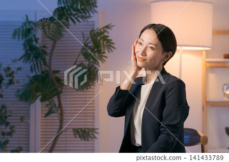 一位身穿西裝的女士正在塗抹護膚品。 一位身穿西裝的女士正在塗抹護膚品。 141433789