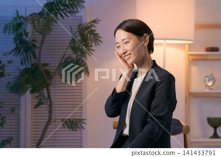 一位身穿西裝的女士正在塗抹護膚品。 一位身穿西裝的女士正在塗抹護膚品。 141433791